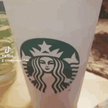 a starbucks cup with a woman 's face on it .