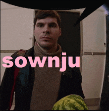 a man is holding a watermelon and the word sownju is written in pink