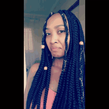 a woman with braids on her hair looks at the camera