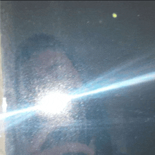 a person taking a picture of themselves in a mirror with a light coming out of it