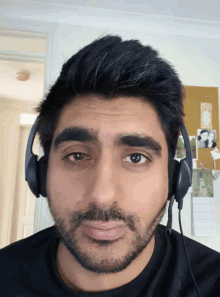 a man wearing headphones looks at the camera