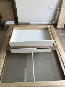 a wooden frame with two white drawers in it