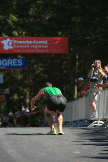 a man is running in front of a sign that says franche-comte conseil regional