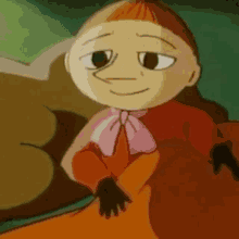 a close up of a cartoon character sitting on a bed with a blanket .