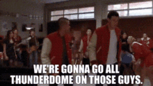 a group of people standing in a gym with the words we 're gonna go all thunderdome on those guys .