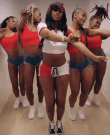 a group of women are dancing together and one of them is wearing a red top