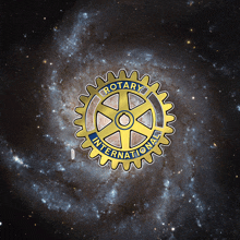 a picture of a rotary international logo in the middle of a galaxy