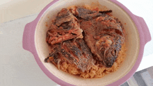 a purple bowl filled with rice and fish on a table