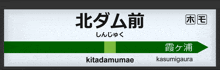 a sign for kitadamumae has a green arrow pointing to the right