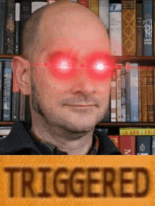 a bald man with red eyes is standing in front of a bookshelf that says triggered on it