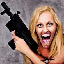 a woman holds a gun with her mouth open