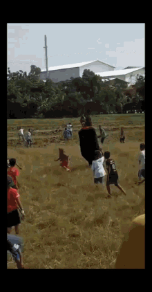 a group of children are playing in a field and one of them is wearing a shirt that says ' a ' on it