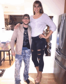 a man and a woman are posing for a picture with the woman wearing a shirt that says ' guess ' on it