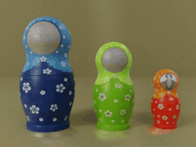 a blue green and orange matryoshka doll with white flowers on it