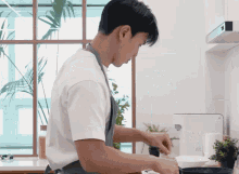 a man in an apron prepares food in a kitchen with a cutting board that says ' cutting board ' on it