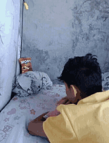 a person laying on a bed with a bag of moby chips on the bed