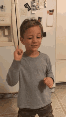 a young boy is standing in front of a refrigerator with a sticker on it that says ' a ' on it