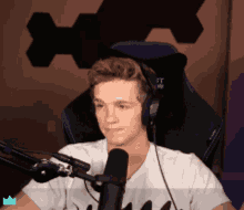 a young man wearing headphones is sitting in front of a microphone