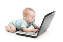 a baby is laying on its stomach looking at a laptop computer .