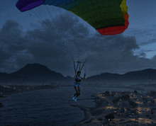 a woman is parasailing over a body of water