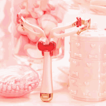 a pink container with hearts on it sits next to a pair of shaving razors