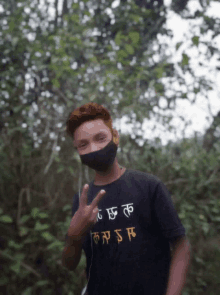 a young man wearing a mask and a black shirt that says ' sr ' on it