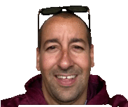 a bald man wearing sunglasses and a maroon jacket smiles for the camera .