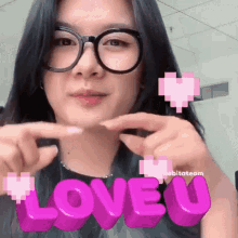 a woman wearing glasses is making a heart shape with her fingers and the word love u behind her