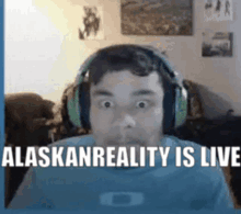 a man wearing headphones and a blue shirt says alaskan reality is live .