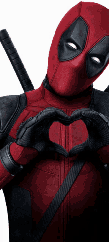 a man in a deadpool costume making a heart shape with his hands