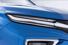 a close up of a blue car 's hood with chrome trim .