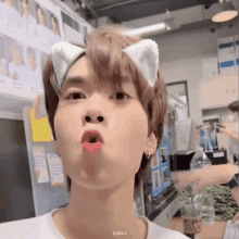 a young man wearing cat ears makes a funny face with his mouth open