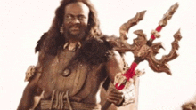 a man with long hair and a beard is holding a trident in his hand .