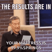 a man sitting in front of a brick wall holding a piece of paper with the words the results are in your mattress