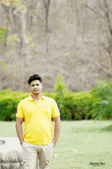 a man in a yellow polo shirt is standing in a field