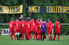 a group of soccer players standing in front of a banner that says angy toutours