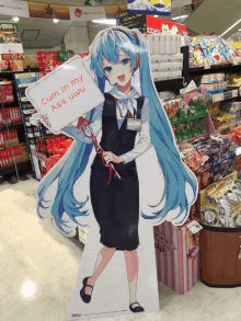 a cardboard cutout of a girl holding a sign that reads cum in my ass uwu