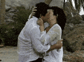 a man and woman are kissing in the rain