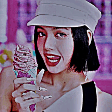 a woman wearing a hat is holding a purple ice cream cone