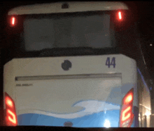 a blue and white bus with the number 44 on the back