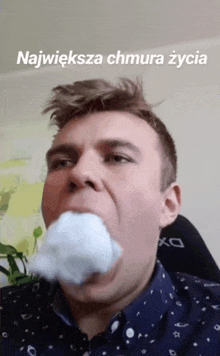 a man with cotton candy in his mouth and the words największa chmura zycia below him