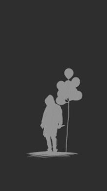 a silhouette of a person holding a bunch of balloons .