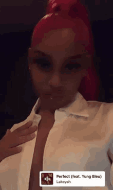 a woman with red hair is taking a selfie with her hand on her chest .