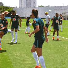 a group of soccer players on a field with one wearing a shirt that says ' banco do brasil ' on it