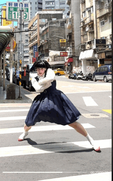 a girl in a blue skirt is crossing the street in front of a sign that says 13 on it