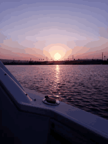 a sunset over a body of water with the sun setting in the distance