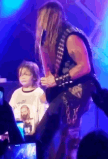 a little girl wearing a shirt that says " i love you " stands next to a man on a stage