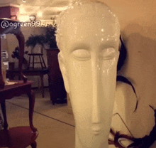 a statue of a woman 's head is displayed in a room with the hashtag @ogreen99