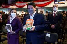 a man wearing a mask holds a book titled coquito