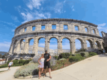 a man and a woman pose in front of an ancient building